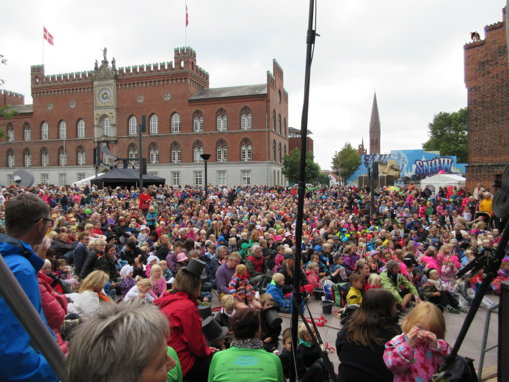 I sine bestræbelser på at skabe et bedre image har Odense udnævnt sig selv til festivalernes by. Her er det de små odenseanere, der er samlet til H.C. Andersens festival.  Snedronningen på kulissen i baggrunden er genbrug fra Sex & Erotikfestivalen 2014. 
